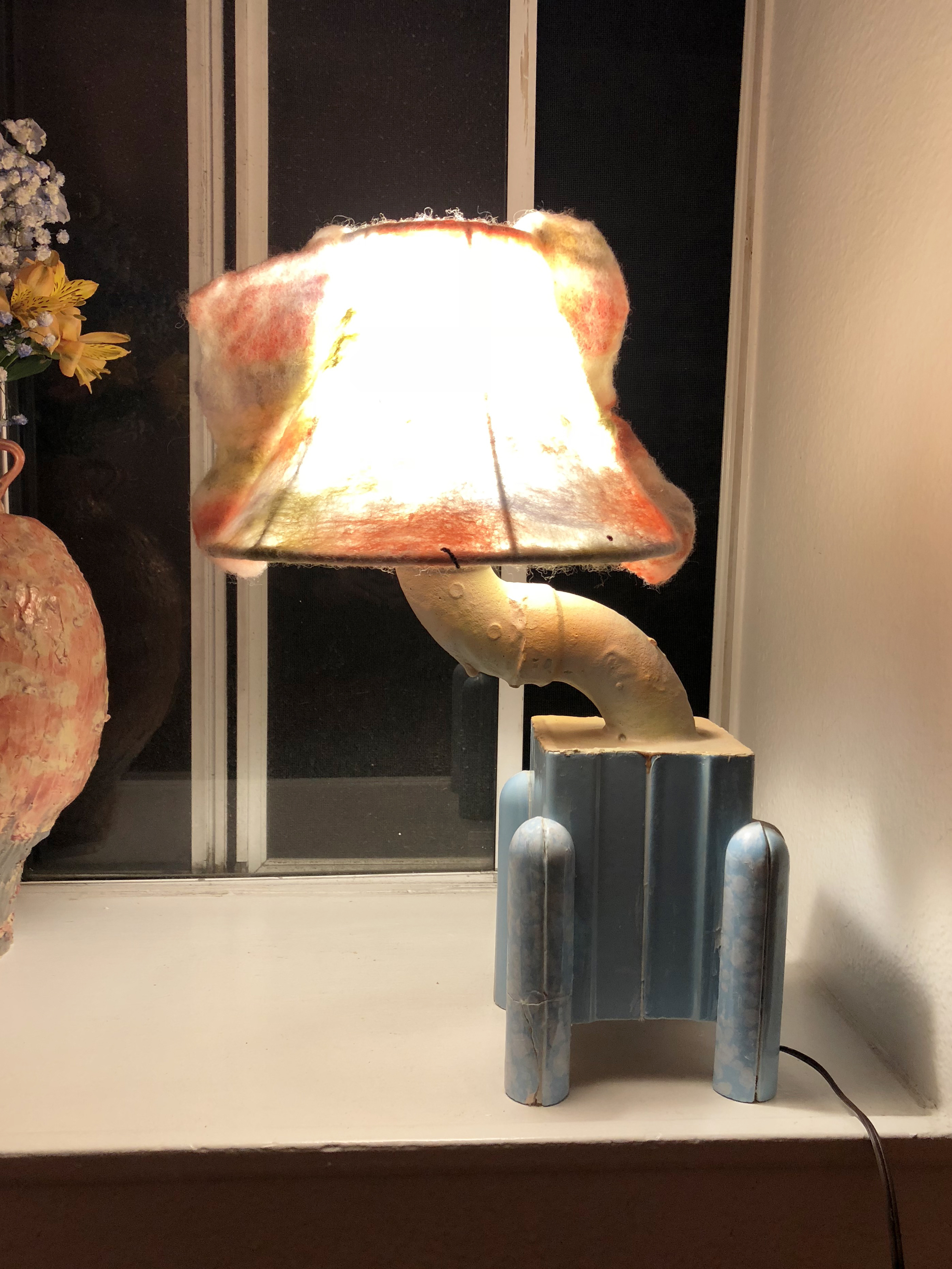 Felt lamp with a blue base on a windowsill
